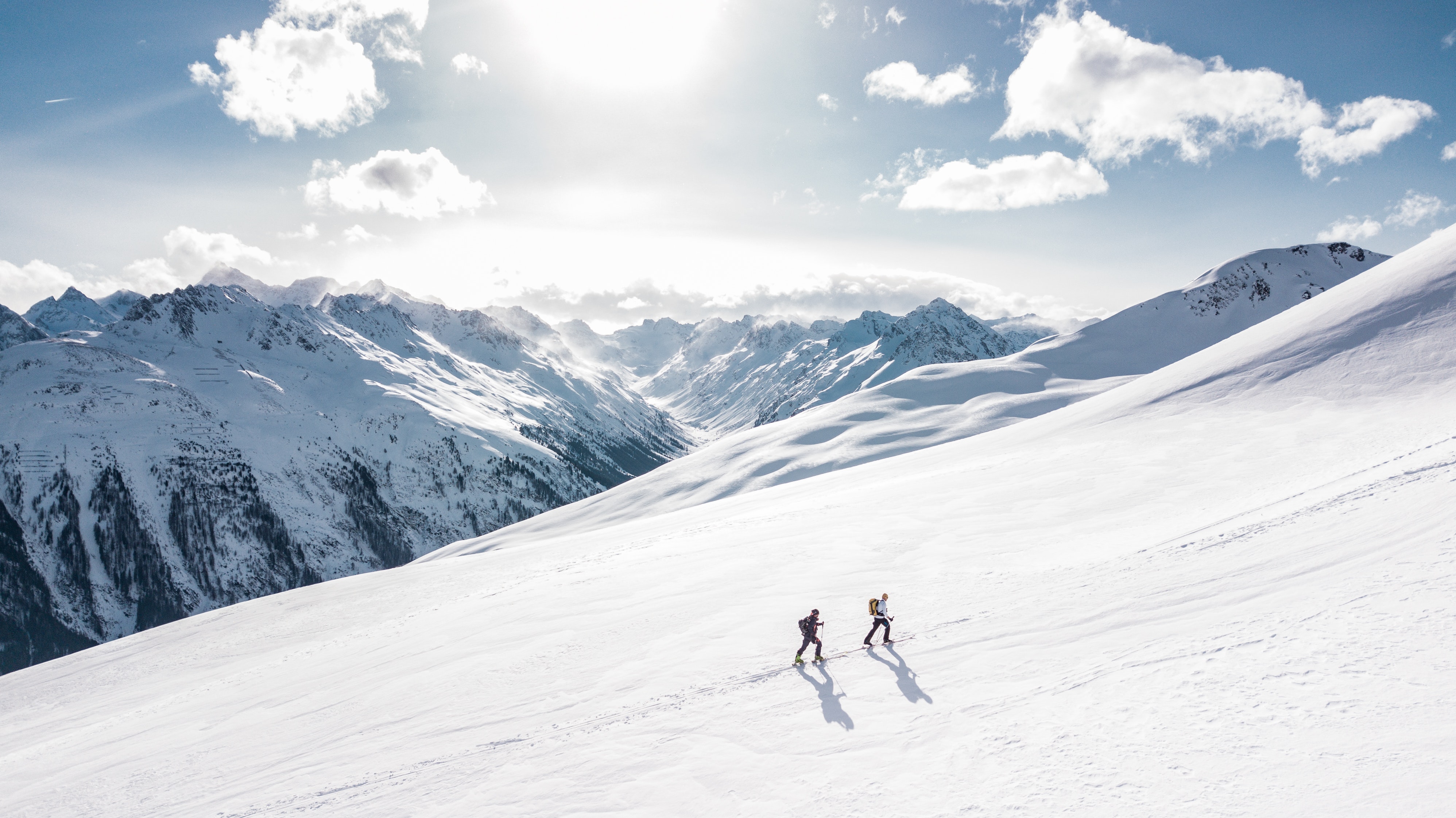 image of ski tourers climbing a large mountain